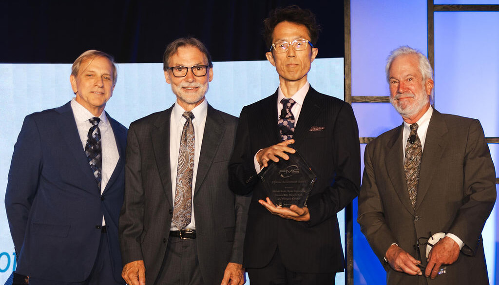 2024 Lifetime Achievement Award co-recipient Ryota Katsumata (holding award) on behalf of his team, with (from left) FMS Lifetime Achievement Award committee members Chuck Sobey, Brian Berg, and Jim Handy